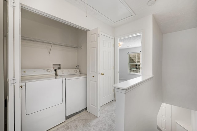 laundry area featuring washing machine and clothes dryer and light carpet