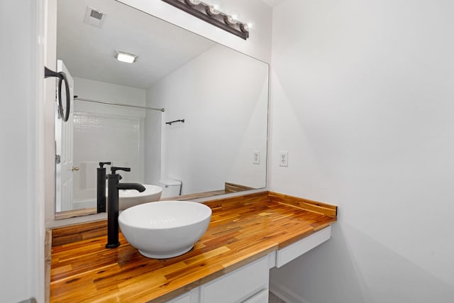 bathroom featuring a shower and vanity