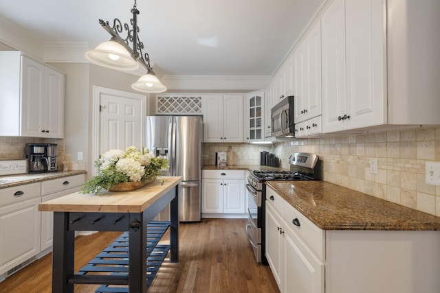 kitchen with white cabinets, pendant lighting, and stainless steel appliances