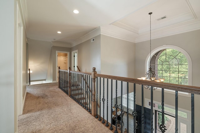 corridor featuring carpet, ornamental molding, and a notable chandelier