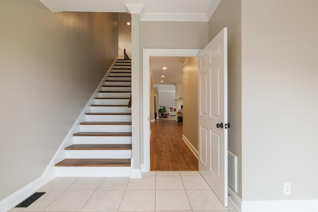 staircase featuring tile patterned floors and ornamental molding