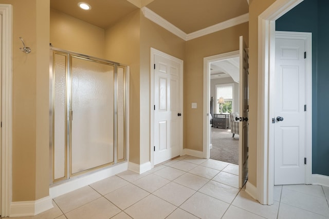 bathroom featuring tile patterned flooring, a shower with shower door, and ornamental molding