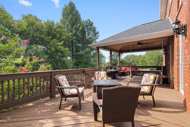 wooden terrace with outdoor lounge area and ceiling fan