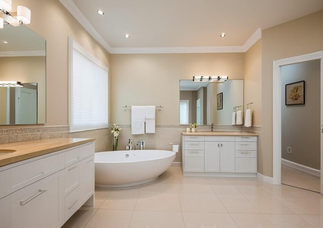 bathroom featuring tile patterned flooring, vanity, a tub to relax in, and ornamental molding