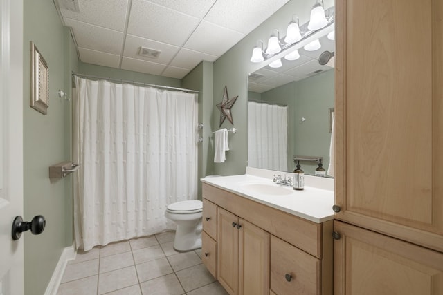 bathroom with vanity, a paneled ceiling, tile patterned floors, and toilet