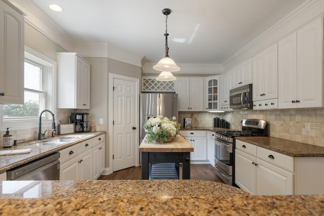 kitchen with white cabinetry, sink, light stone counters, and appliances with stainless steel finishes