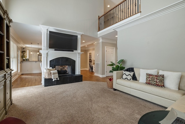 living room with crown molding, light wood-type flooring, and a fireplace