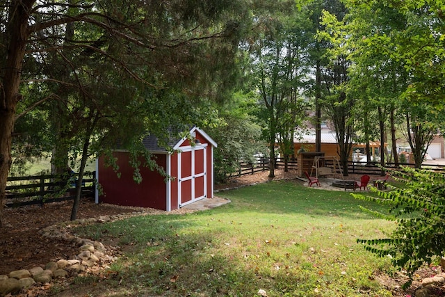 view of yard featuring a fire pit and a storage shed