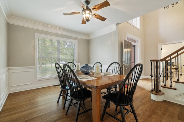 dining room with ceiling fan, ornamental molding, and dark wood-type flooring