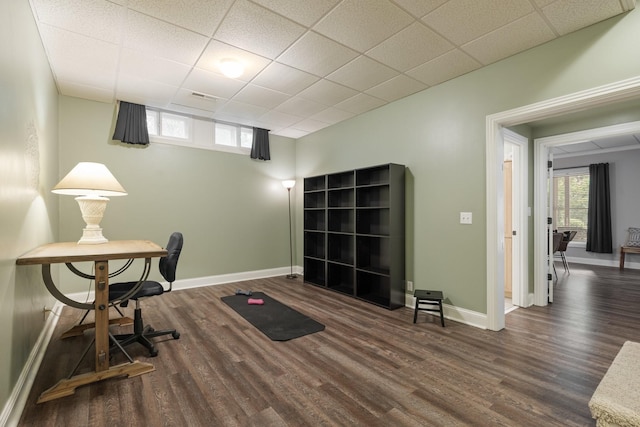 office with dark hardwood / wood-style flooring and a paneled ceiling