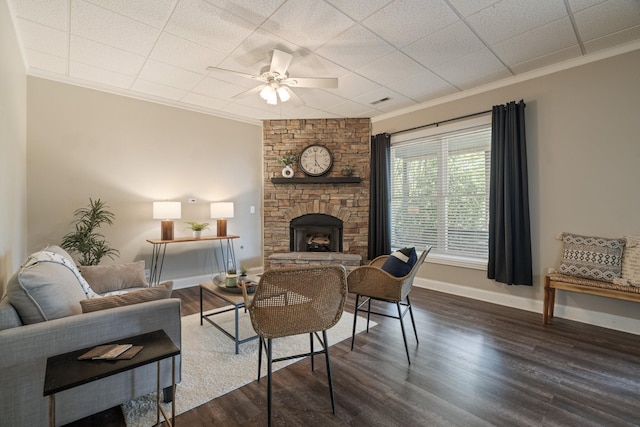 living room with a fireplace, dark hardwood / wood-style floors, ceiling fan, and ornamental molding