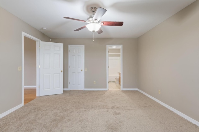 unfurnished bedroom with light carpet, ensuite bathroom, and ceiling fan