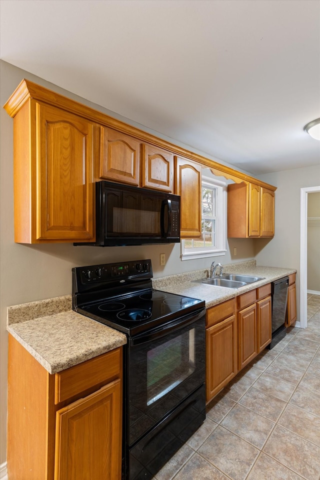 kitchen with black appliances, light tile patterned flooring, and sink