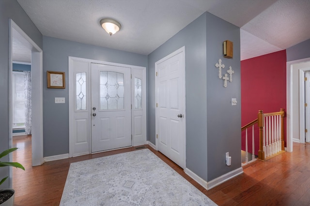 entrance foyer featuring dark hardwood / wood-style flooring and a textured ceiling