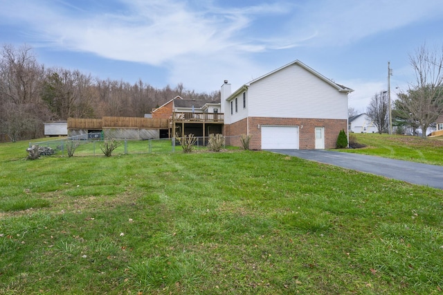 exterior space featuring a deck, a front lawn, and a garage