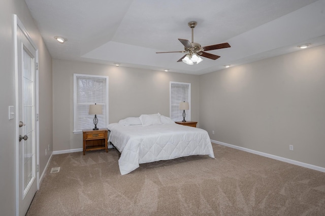 bedroom with carpet, ceiling fan, and a raised ceiling