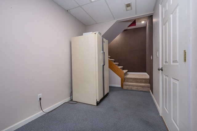 interior space featuring a paneled ceiling, white refrigerator, and carpet floors