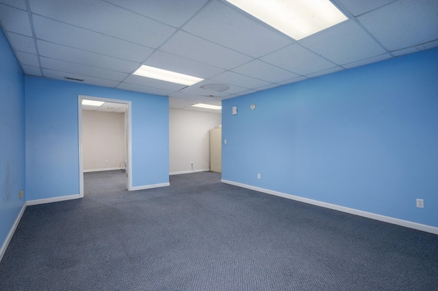 carpeted spare room with a drop ceiling