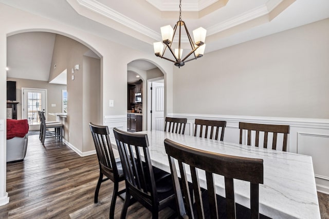 dining room with a chandelier, a tray ceiling, dark hardwood / wood-style floors, and crown molding