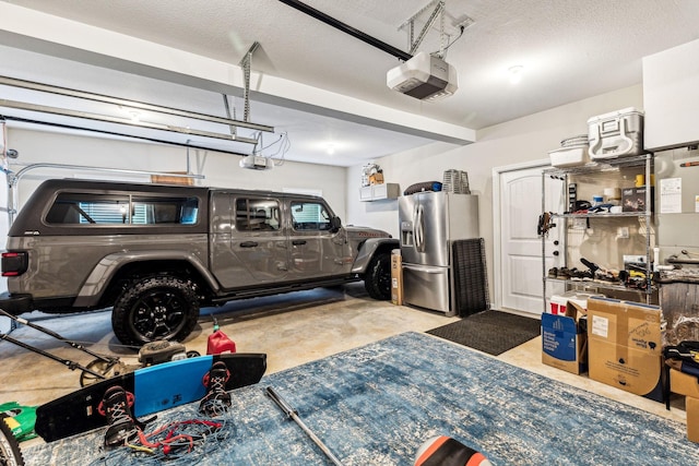 garage with stainless steel refrigerator with ice dispenser and a garage door opener