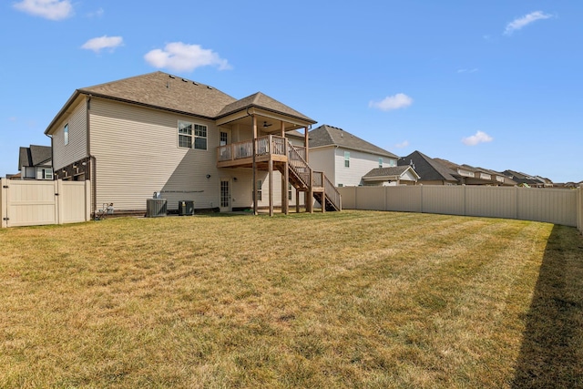 rear view of property with a yard, a wooden deck, and central air condition unit