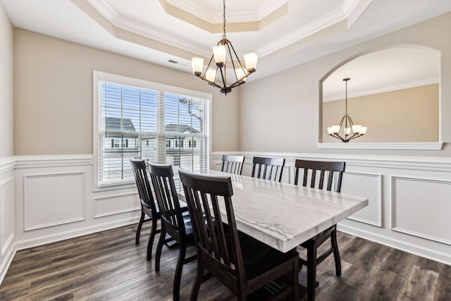 dining room featuring a notable chandelier, dark hardwood / wood-style flooring, a raised ceiling, and ornamental molding