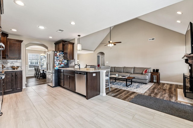 kitchen with dark brown cabinetry, ceiling fan, decorative backsplash, and appliances with stainless steel finishes