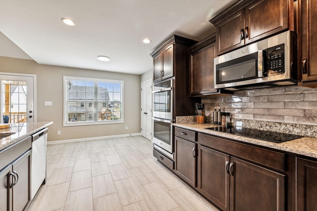 kitchen featuring dark brown cabinets, backsplash, stainless steel appliances, and light stone counters