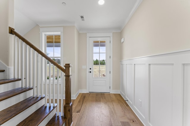 doorway to outside with hardwood / wood-style floors and ornamental molding