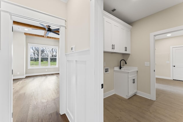 laundry area with cabinets, sink, washer hookup, ceiling fan, and light wood-type flooring