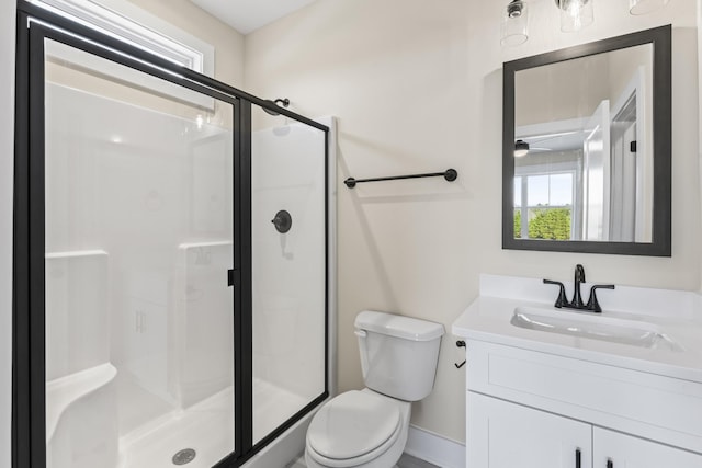 bathroom with vanity, toilet, and a shower with door