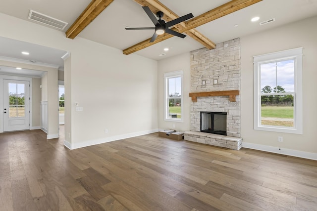 unfurnished living room featuring beamed ceiling, hardwood / wood-style flooring, a fireplace, and ceiling fan