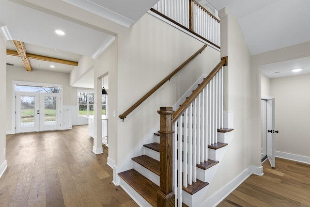 stairs featuring beam ceiling, french doors, coffered ceiling, and hardwood / wood-style floors