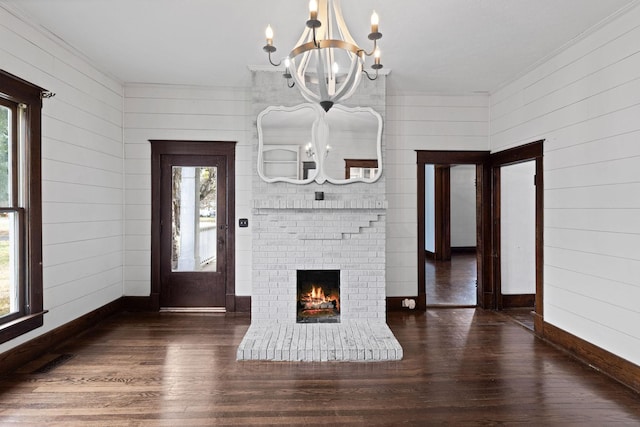 interior space featuring a notable chandelier, dark hardwood / wood-style floors, and a fireplace