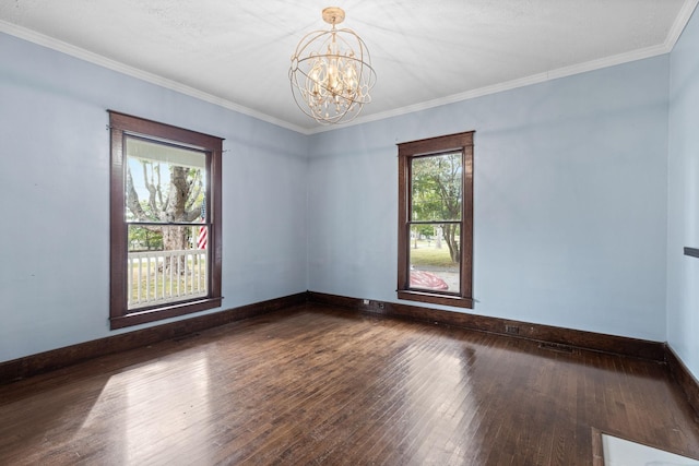 spare room featuring a notable chandelier, dark hardwood / wood-style flooring, and ornamental molding