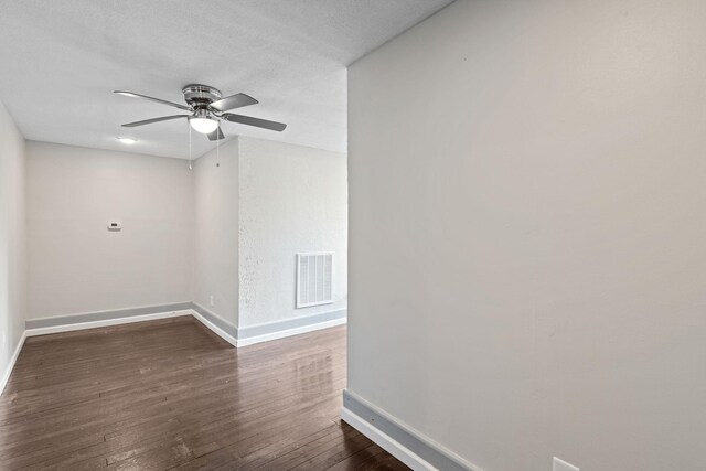 empty room featuring ceiling fan, dark hardwood / wood-style flooring, and a textured ceiling