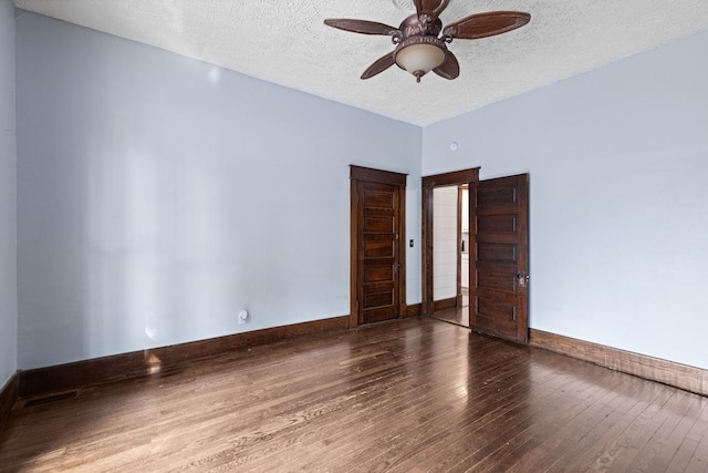 empty room with ceiling fan, wood-type flooring, and a textured ceiling