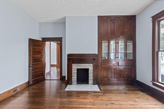 unfurnished living room with dark hardwood / wood-style floors and a textured ceiling