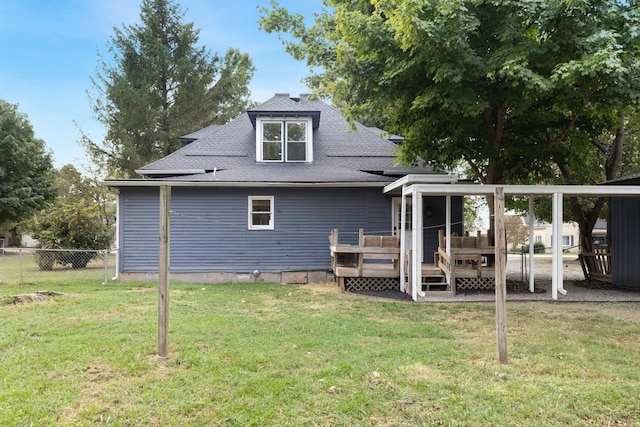 rear view of property featuring a yard and a wooden deck