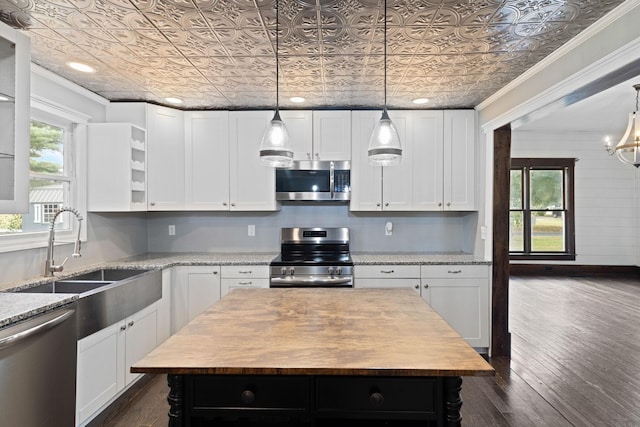 kitchen featuring a center island, white cabinets, sink, appliances with stainless steel finishes, and light stone counters