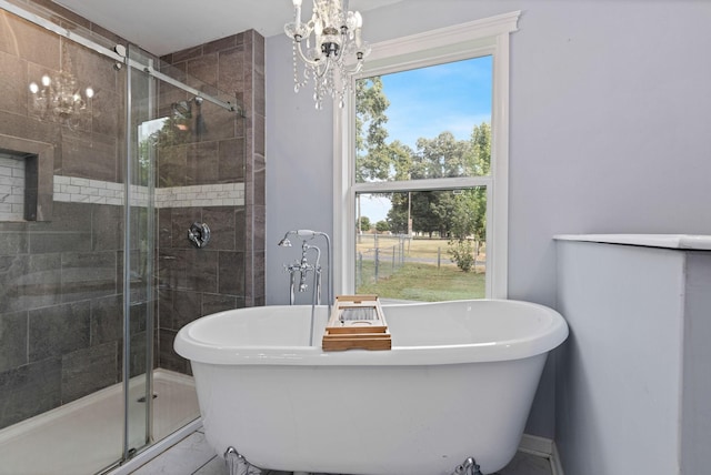 bathroom with separate shower and tub, an inviting chandelier, and a healthy amount of sunlight