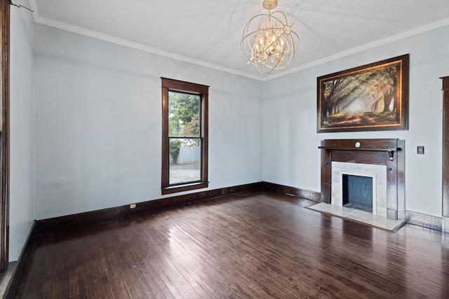 unfurnished living room featuring a fireplace, hardwood / wood-style floors, crown molding, and a notable chandelier