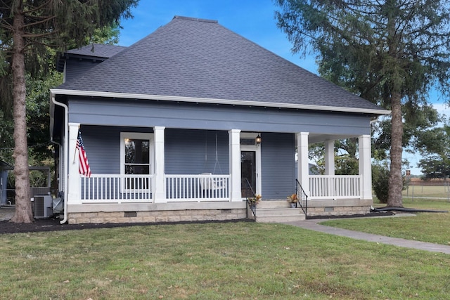 view of front of property with cooling unit, covered porch, and a front yard