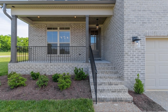 doorway to property with covered porch and a garage