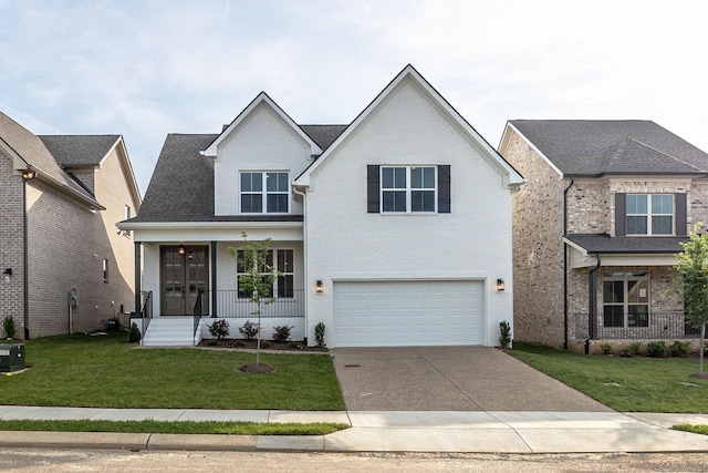 view of front of house featuring covered porch, a garage, and a front lawn