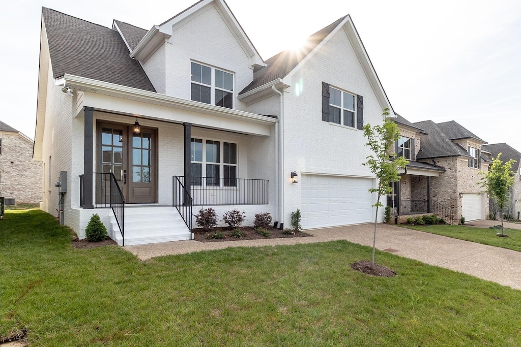 view of front of property with french doors, a front lawn, a porch, and a garage