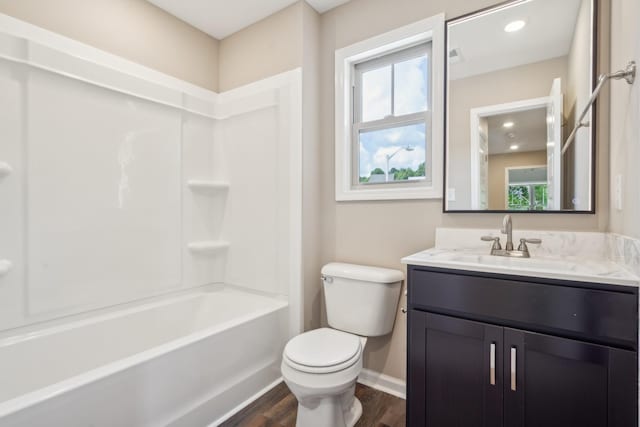 full bathroom with hardwood / wood-style floors, vanity, tub / shower combination, and toilet