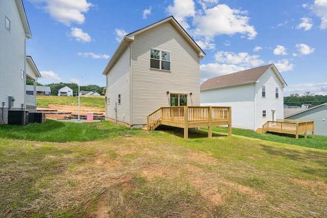 back of house with central AC, a deck, and a lawn