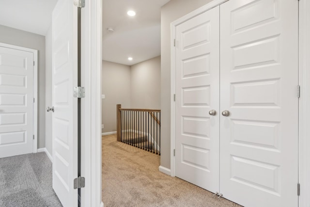 corridor featuring light colored carpet