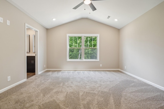 unfurnished bedroom with ceiling fan, lofted ceiling, light carpet, and ensuite bath